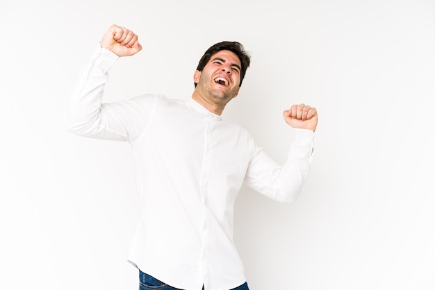 Joven celebrando un día especial, salta y levanta los brazos con energía.