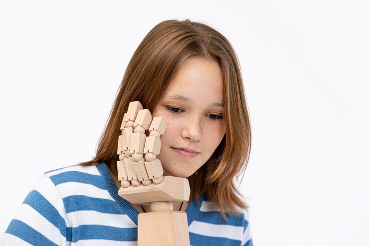 Foto una joven se centra en su trabajo artístico con un modelo de mano de madera en un estudio