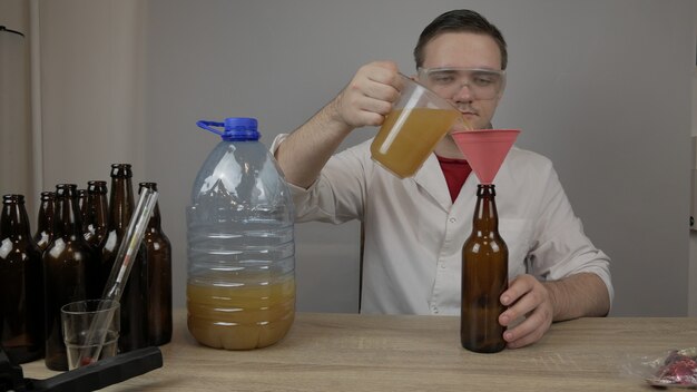 Un joven cervecero prepara productos y comprueba la calidad del equipo y la calidad de la cerveza de miel elaborada en casa.