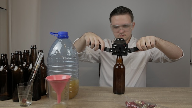 Foto un joven cervecero prepara productos y comprueba la calidad del equipo y la calidad de la cerveza de miel elaborada en casa.