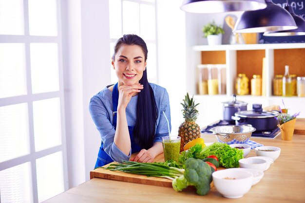 Joven con cesta de verduras frescas en la cocina.