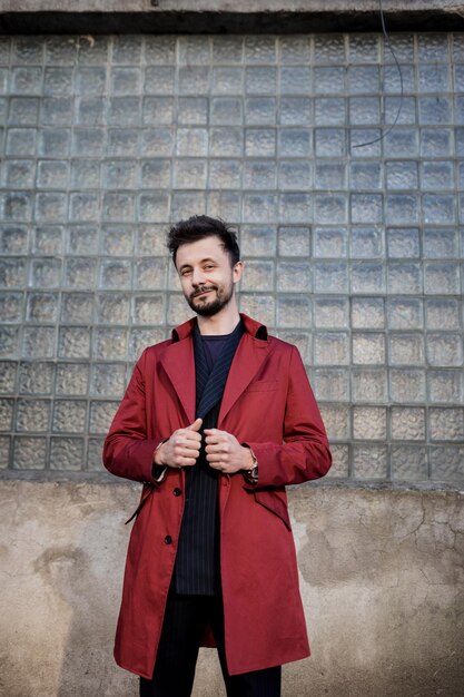 Joven con una chaqueta roja en el fondo de la ciudad grunge