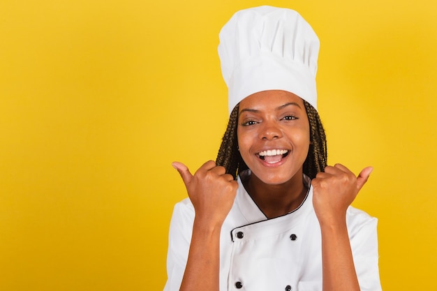 Joven chef afrobrasileña con pulgar arriba aprobación como afirmativa