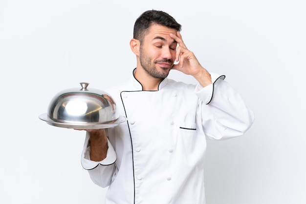 Joven chef con bandeja aislado sobre fondo blanco riendo