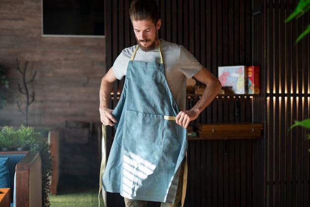 Un joven chef barbudo con delantal en el restaurante.