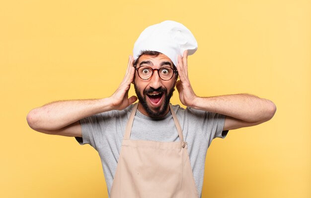 Joven chef barbudo hombre sorprendido expresión