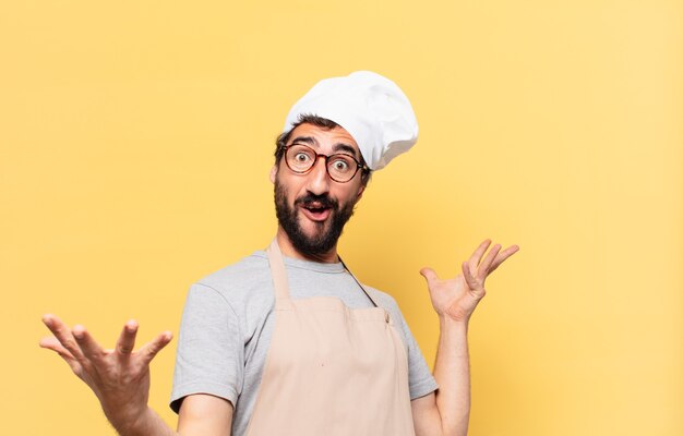 Joven chef barbudo hombre sorprendido expresión