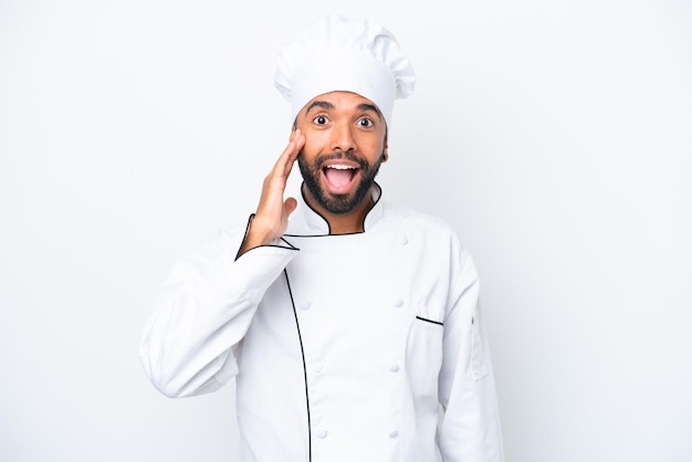 Joven chef brasileño aislado de fondo blanco con expresión facial sorprendida y sorprendida