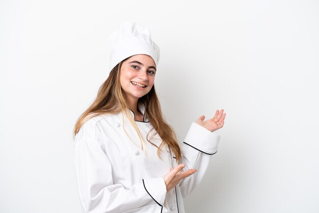Joven chef caucásica mujer aislada de fondo blanco extendiendo las manos a un lado para invitar a venir