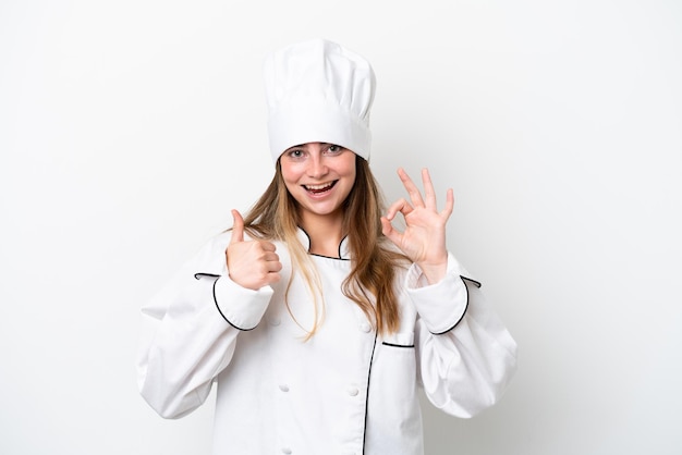 Joven chef caucásica mujer aislada sobre fondo blanco que muestra el signo de ok y el pulgar hacia arriba gesto