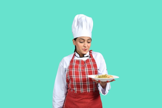 joven chef chica traje blanco sosteniendo un plato modelo paquistaní indio