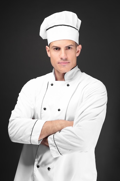 Joven chef masculino sobre fondo oscuro