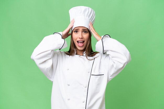 Joven chef mujer caucásica sobre fondo aislado con expresión de sorpresa