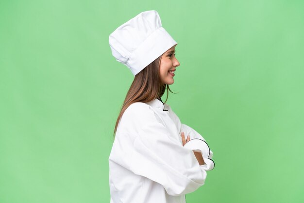 Joven chef mujer caucásica sobre fondo aislado en posición lateral