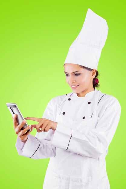 Joven chef usando un teléfono en el estudio