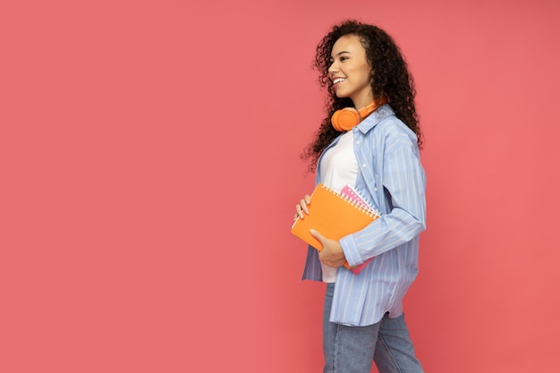 Joven chica atractiva con auriculares sobre un fondo rojo