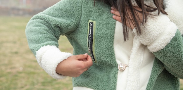 Foto joven chica cerrando el bolsillo de la ropa de invierno