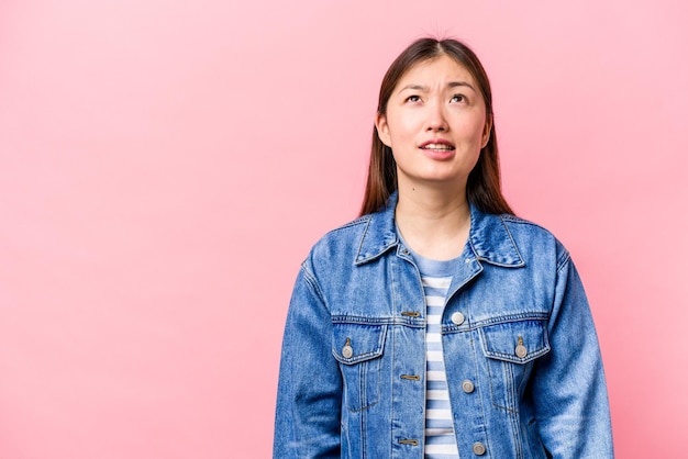 Joven china aislada de fondo rosa gritando concepto de rabia muy enojado frustrado