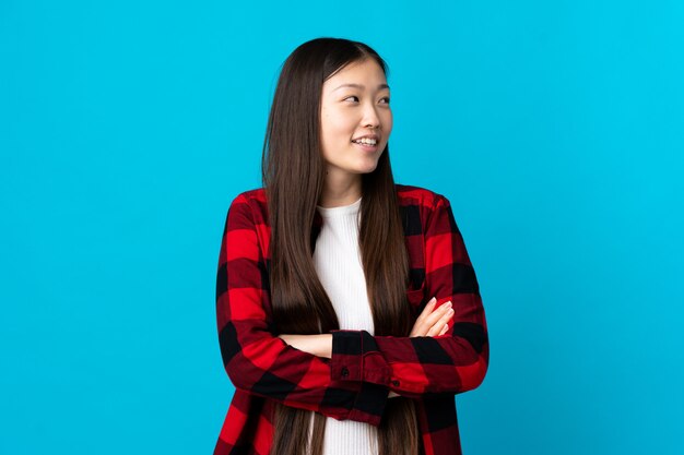 Joven china en azul aislado feliz y sonriente