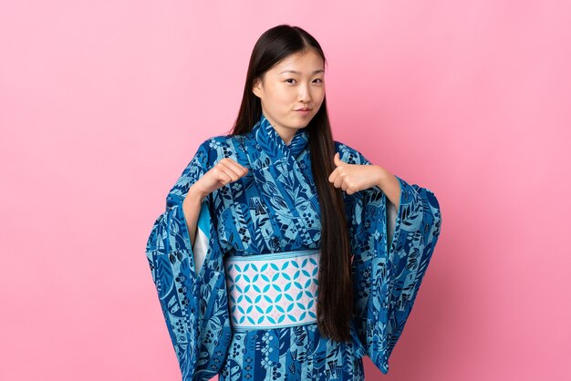 Foto joven china con kimono sobre pared aislada orgullosa y satisfecha de sí misma