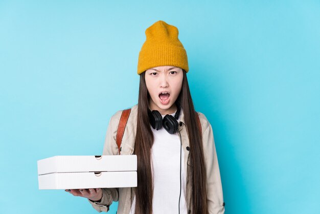 Joven china sosteniendo pizzas gritando muy enojado y agresivo.