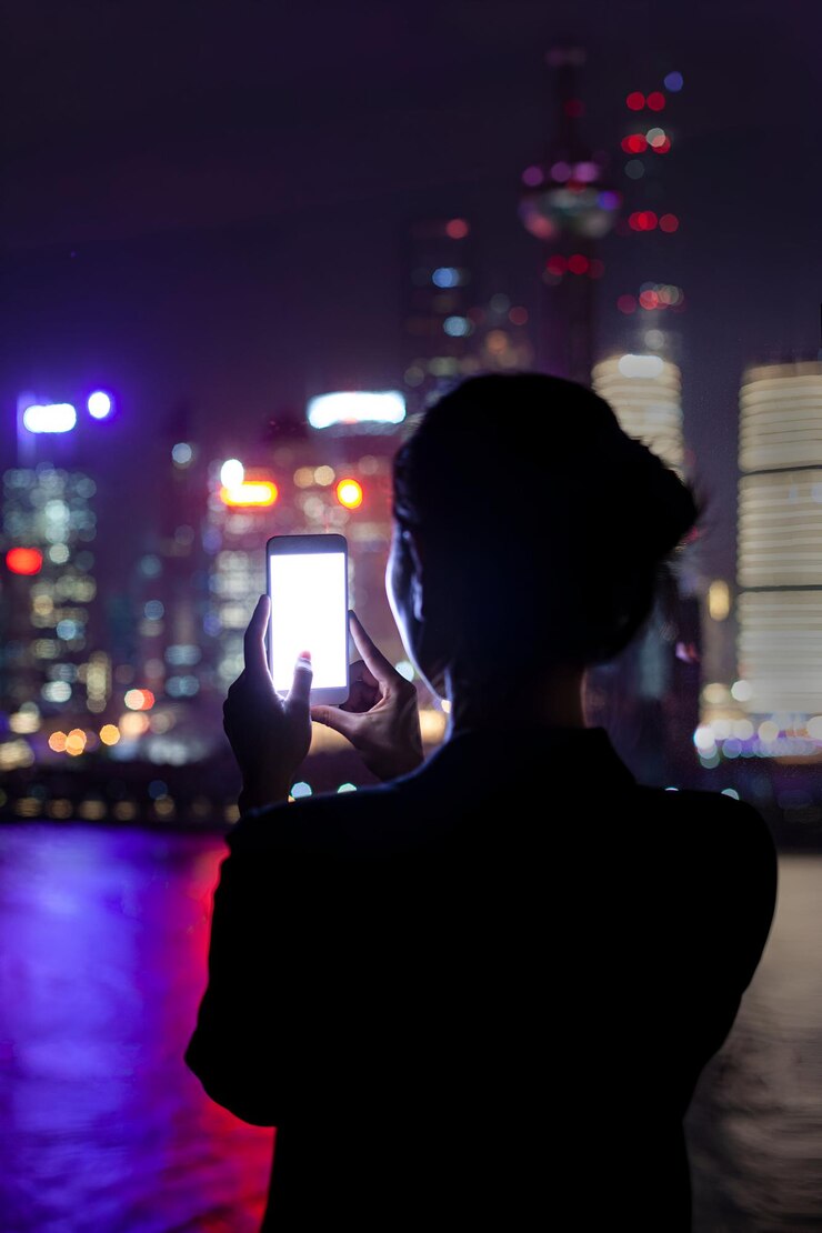 Foto una joven china usa su teléfono inteligente para tomar fotos en el centro de shanghai, china.