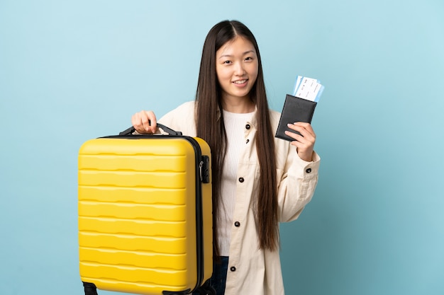 Joven China de vacaciones con maleta y pasaporte