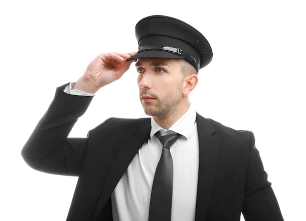 Foto joven chofer ajustando su sombrero sobre fondo blanco.