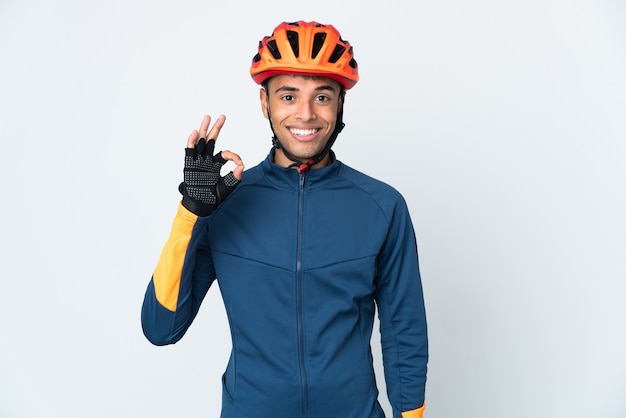 Joven ciclista brasileño aislado sobre fondo blanco mostrando signo ok con los dedos