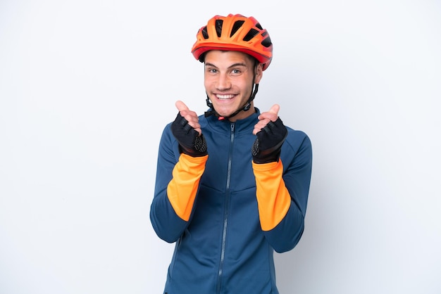 Foto joven ciclista hombre caucásico aislado sobre fondo blanco haciendo gesto de dinero