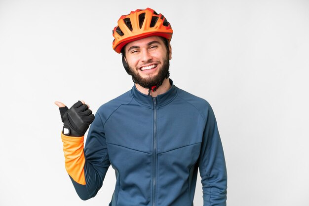 Foto joven ciclista sobre fondo blanco aislado apuntando hacia un lado para presentar un producto