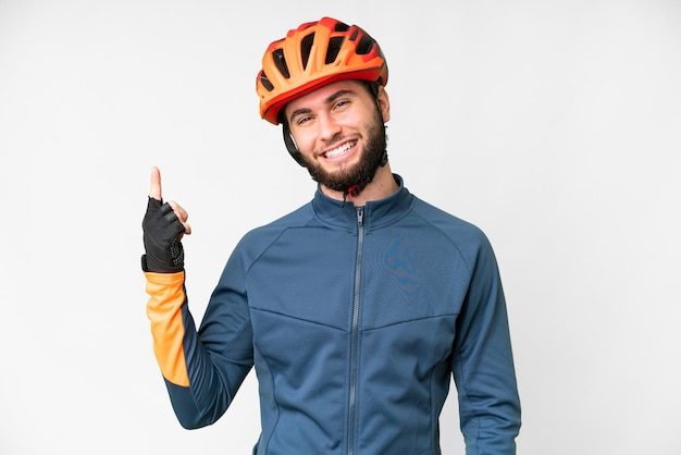 Joven ciclista sobre fondo blanco aislado mostrando y levantando un dedo en señal de lo mejor