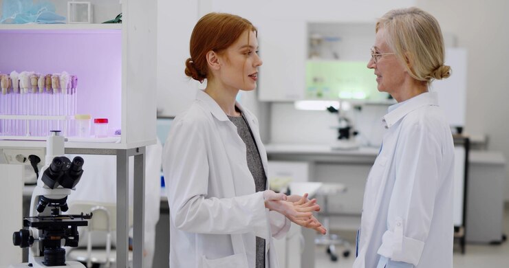Joven científica discutiendo el resultado de la investigación de virus con un supervisor en el laboratorio
