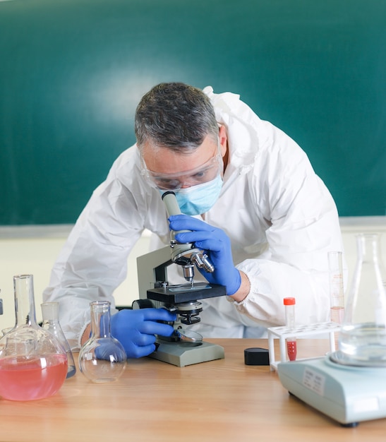 Un joven científico mira a través de un microscopio en el laboratorio.