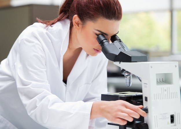 Joven científico mirando en un microscopio