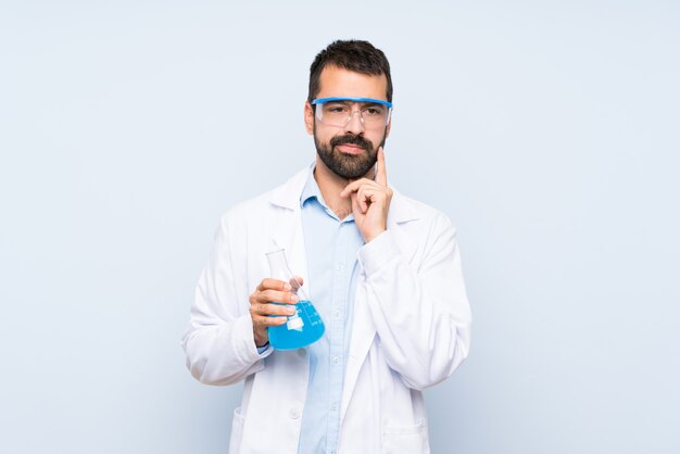 Joven científico sosteniendo frasco de laboratorio sobre aislado mirando al frente