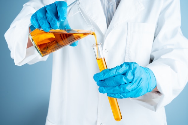 Joven científico con tubo de ensayo haciendo investigación en laboratorio clínico.