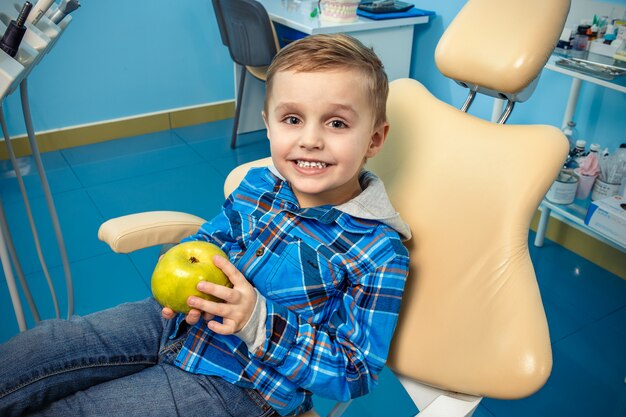 Joven en una cirugía dental con una manzana en la mano