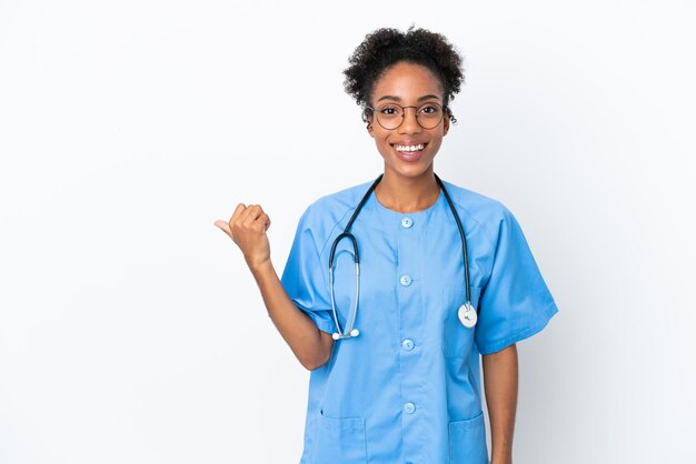 Joven cirujano médico afroamericano mujer aislada sobre fondo blanco apuntando hacia el lado para presentar un producto