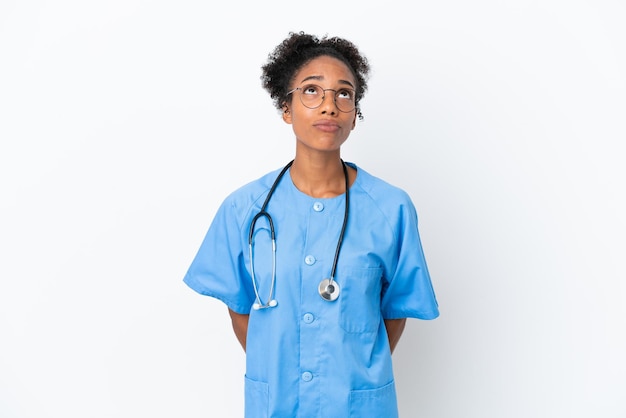 Joven cirujano médico afroamericano mujer aislada sobre fondo blanco y mirando hacia arriba