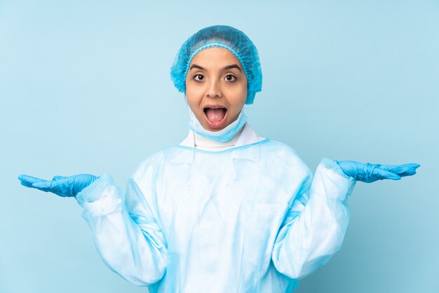 Joven cirujano en uniforme azul con expresión facial sorprendida