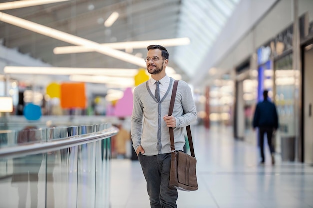 Un joven cliente feliz y moderno camina por el centro comercial