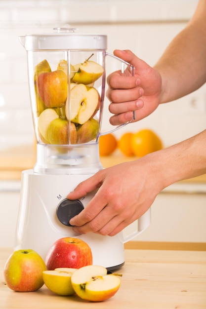 Foto joven cocinando batido de manzana en licuadora