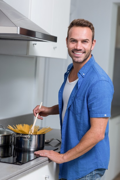 Joven cocinando espagueti