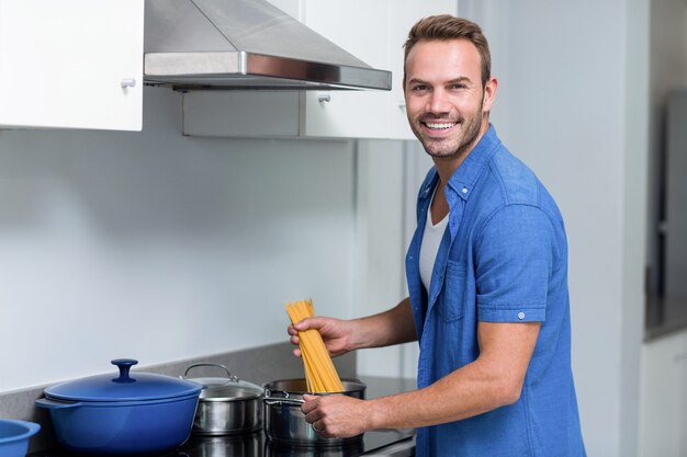 Joven cocinando espagueti