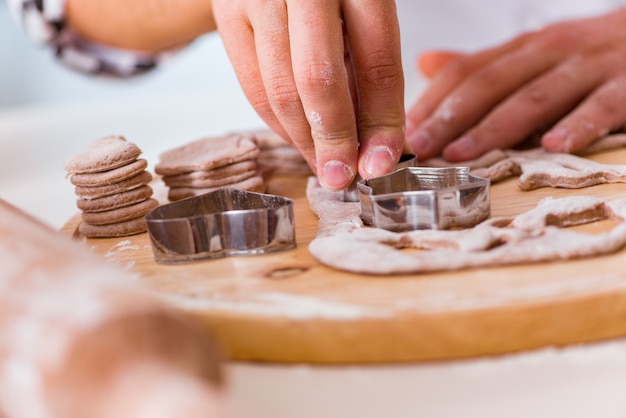 Joven cocinando galletas en la cocina