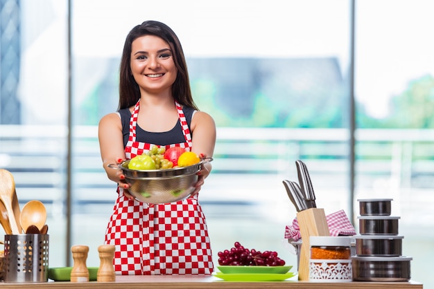 Joven cocinero con frutas en la cocina.