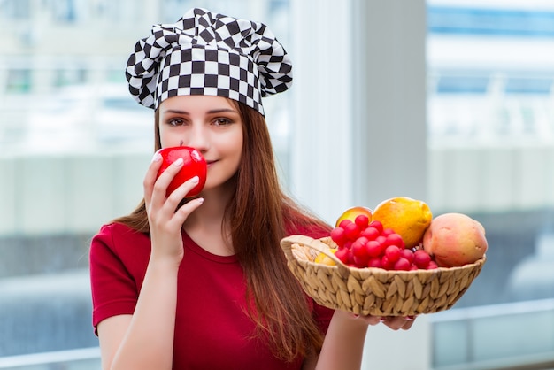 Joven cocinero con frutas en la cocina.