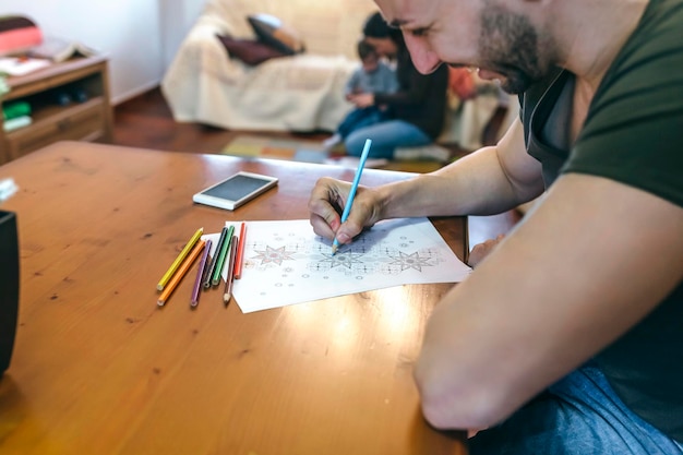 Joven coloreando mandalas en la sala de estar