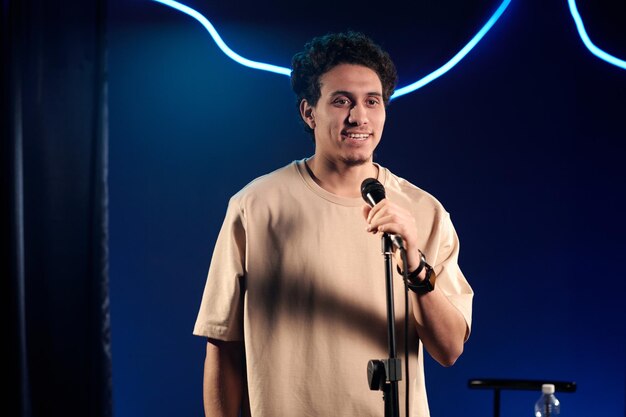 Joven comediante en camiseta beige